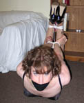Sandra lounges in corset and heels when she is subdued and tape gagged